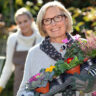 A mother holding a basket of flowers, a perfect Mother's Day garden gift.