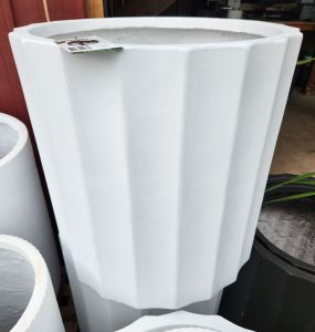 The GardenLite Grecian Cylinder White S 39x39cm planter stands upright with a price tag on its rim, displayed next to other similar-sized pots.
